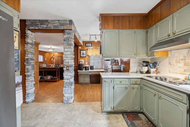 kitchen featuring green cabinets, light wood-type flooring, ornate columns, track lighting, and kitchen peninsula