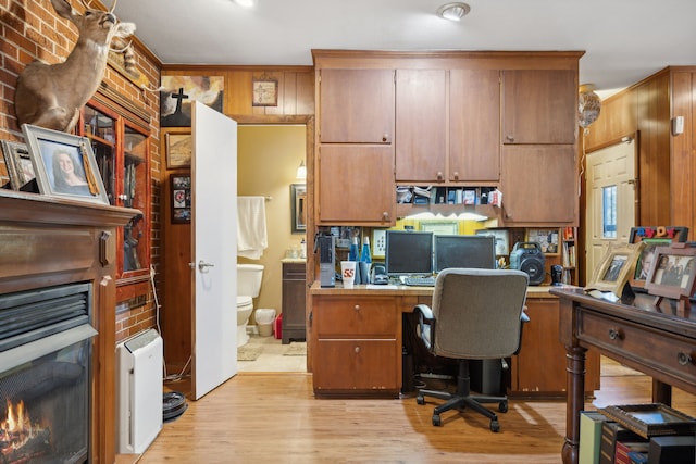 home office featuring light wood-type flooring, built in desk, and ornamental molding