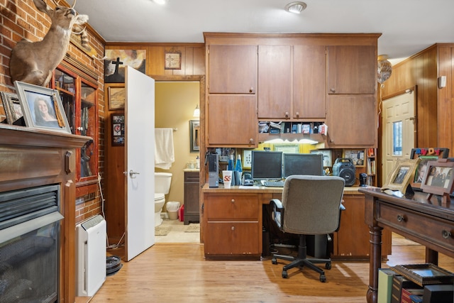 office with built in desk, light hardwood / wood-style floors, and crown molding
