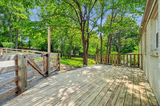 wooden deck featuring a lawn