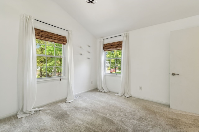 unfurnished room with lofted ceiling and light colored carpet