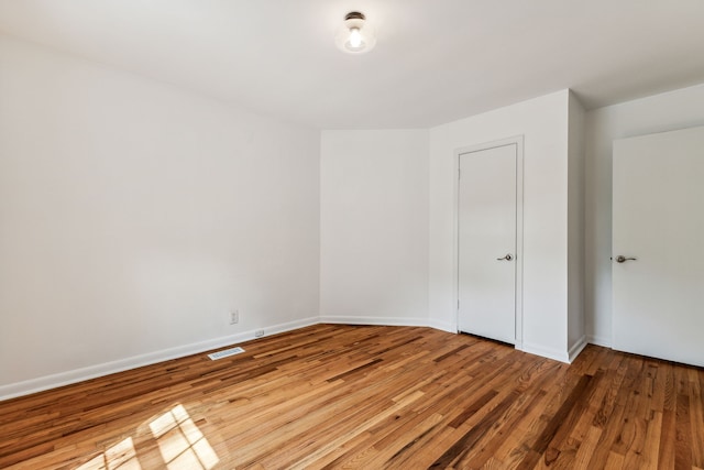 empty room with hardwood / wood-style floors