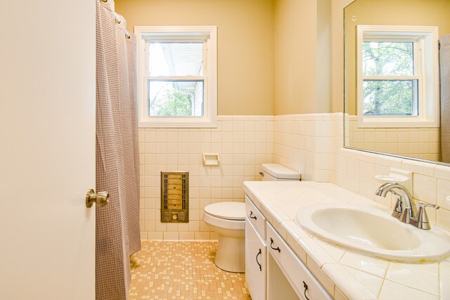 bathroom featuring tile patterned flooring, toilet, tile walls, decorative backsplash, and vanity