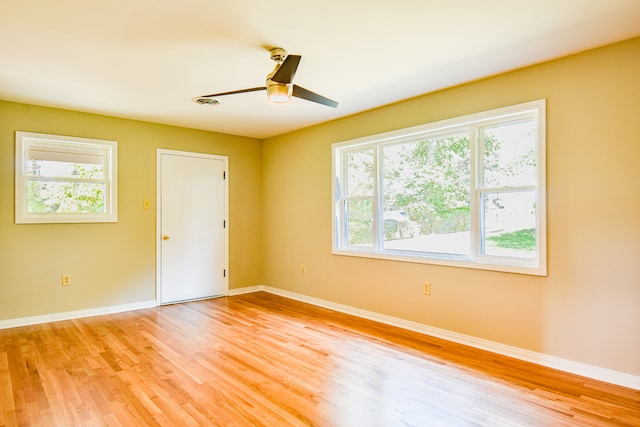 unfurnished room with light hardwood / wood-style flooring, ceiling fan, and a healthy amount of sunlight