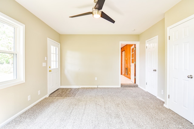 carpeted spare room featuring ceiling fan