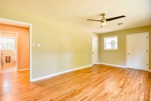 spare room with light wood-type flooring, plenty of natural light, and ceiling fan