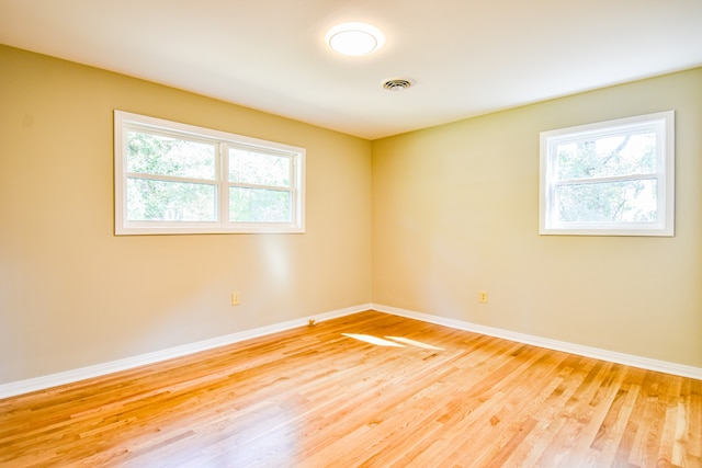 unfurnished room with plenty of natural light and light hardwood / wood-style floors