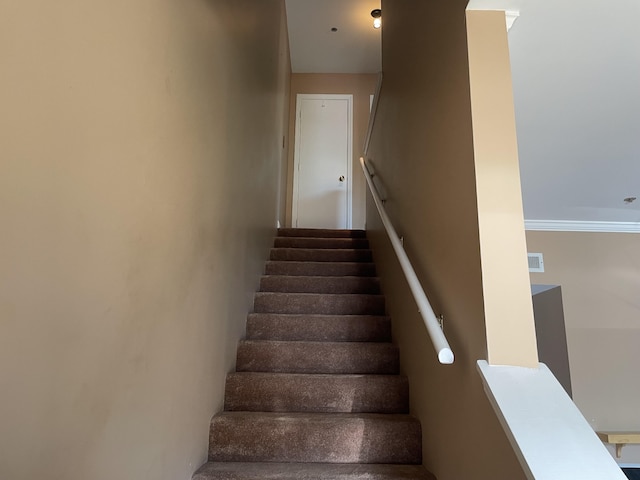 staircase featuring ornamental molding