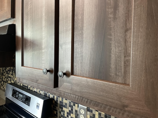 room details with decorative backsplash and stainless steel stove