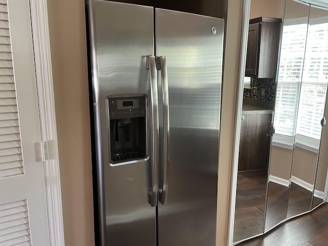 kitchen with stainless steel fridge, tasteful backsplash, a wealth of natural light, and dark wood-type flooring