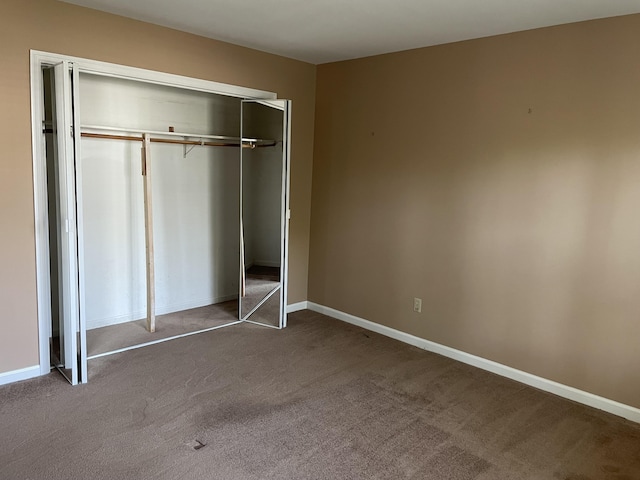 unfurnished bedroom with carpet flooring and a closet