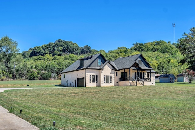 view of front of property with a storage shed and a front yard