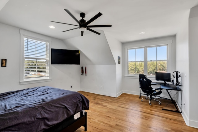 bedroom featuring vaulted ceiling, ceiling fan, wood-type flooring, and multiple windows