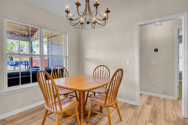 dining room with light wood-type flooring and a chandelier