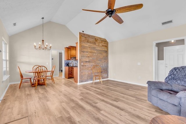 interior space featuring ceiling fan with notable chandelier, light wood-type flooring, and high vaulted ceiling