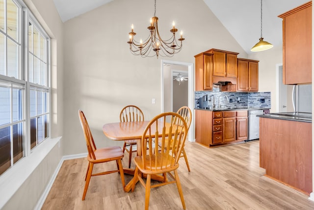 dining room with high vaulted ceiling, light hardwood / wood-style flooring, and a chandelier