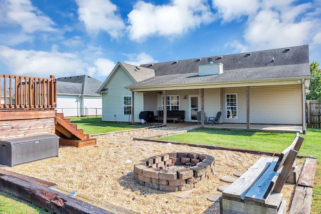 rear view of property with an outdoor fire pit, a yard, and a patio area