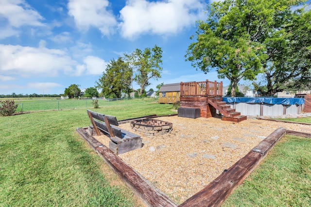 view of yard featuring a pool side deck and a fire pit