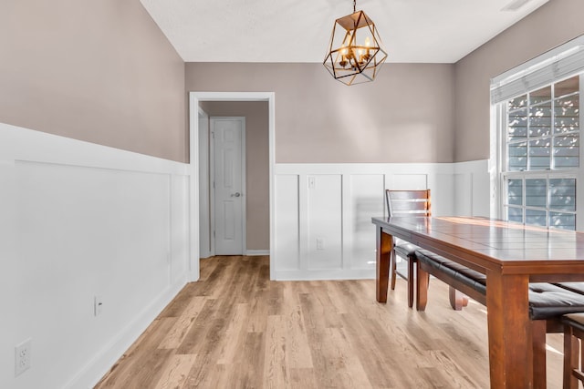 unfurnished dining area featuring light wood-type flooring and an inviting chandelier