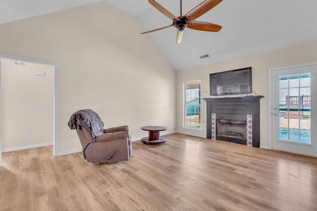 living area featuring light wood-type flooring, ceiling fan, and high vaulted ceiling