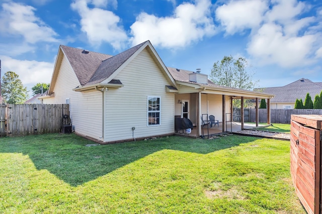 rear view of property featuring a lawn and a patio