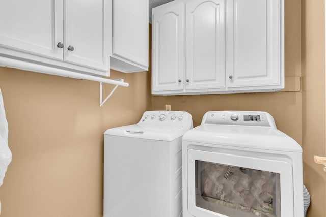 washroom featuring cabinets and washing machine and dryer