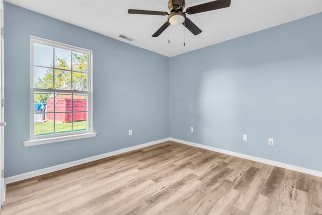 spare room with ceiling fan, plenty of natural light, and light hardwood / wood-style flooring