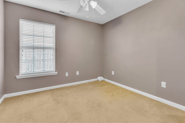 spare room with a textured ceiling, ceiling fan, and carpet floors