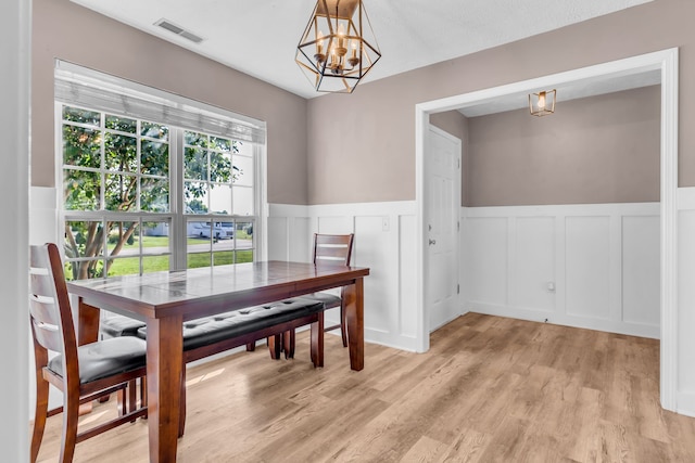 dining area featuring light wood-type flooring and a chandelier