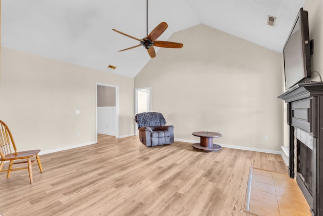 sitting room featuring light wood-type flooring, high vaulted ceiling, and ceiling fan