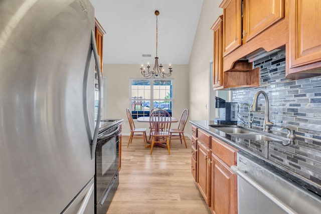 kitchen featuring pendant lighting, a chandelier, light hardwood / wood-style flooring, stainless steel appliances, and sink