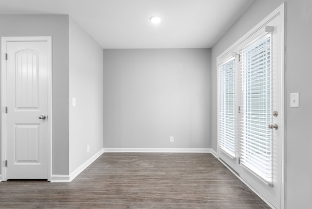 unfurnished room featuring a healthy amount of sunlight and dark hardwood / wood-style flooring