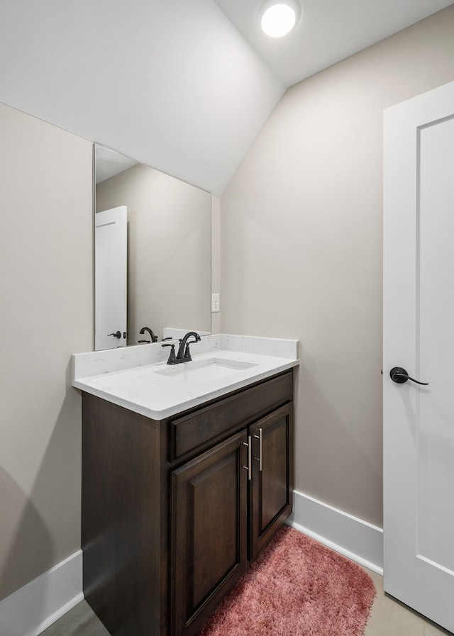 bathroom with vanity and vaulted ceiling