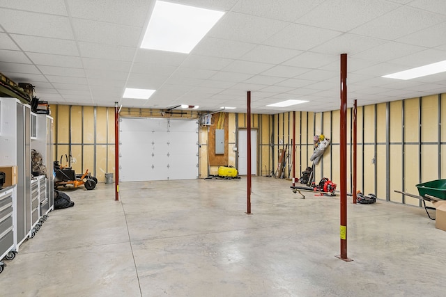 basement with a paneled ceiling and electric panel