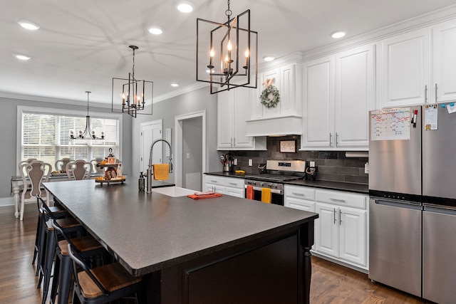 kitchen with dark hardwood / wood-style flooring, stainless steel appliances, and an island with sink