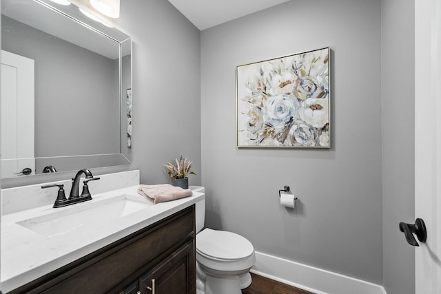 bathroom with vanity, toilet, and hardwood / wood-style floors