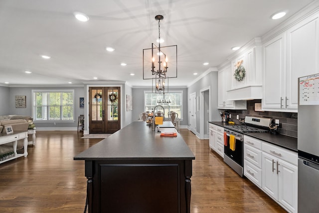 kitchen featuring dark wood-type flooring, stainless steel appliances, a kitchen island with sink, and sink