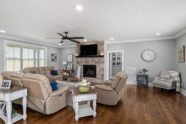 living room featuring dark wood-type flooring, ceiling fan, ornamental molding, and a fireplace