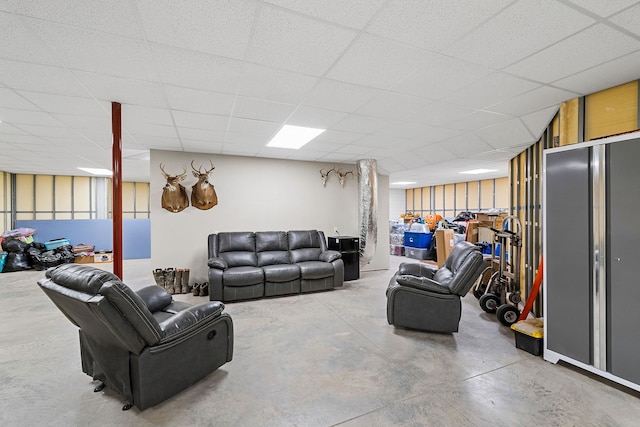 living room featuring concrete floors and a drop ceiling