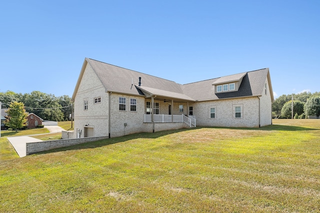 rear view of property featuring a lawn