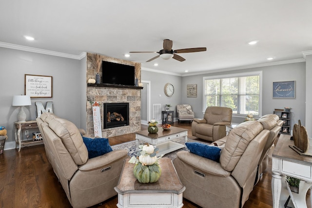 living room featuring ceiling fan, ornamental molding, dark hardwood / wood-style flooring, and a stone fireplace