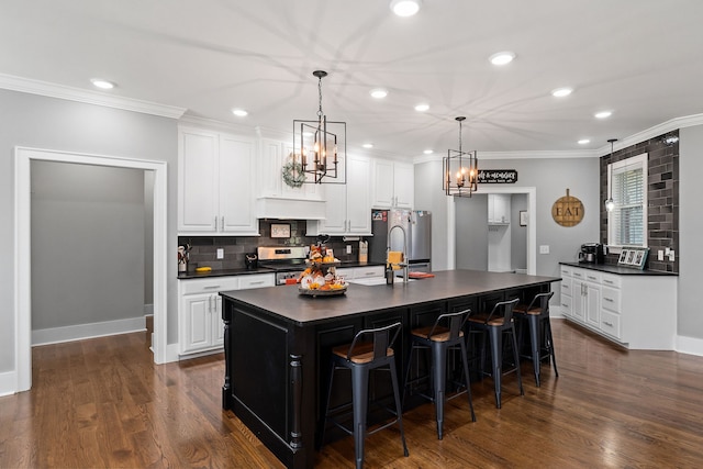 kitchen featuring dark wood-type flooring, a spacious island, stainless steel appliances, and white cabinetry