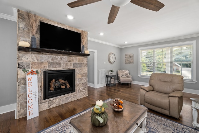 living room with ceiling fan, a fireplace, dark hardwood / wood-style floors, and crown molding