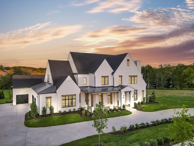 modern farmhouse featuring a porch and a lawn