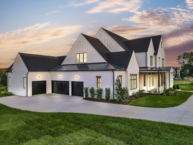 view of front of property with a garage and a lawn