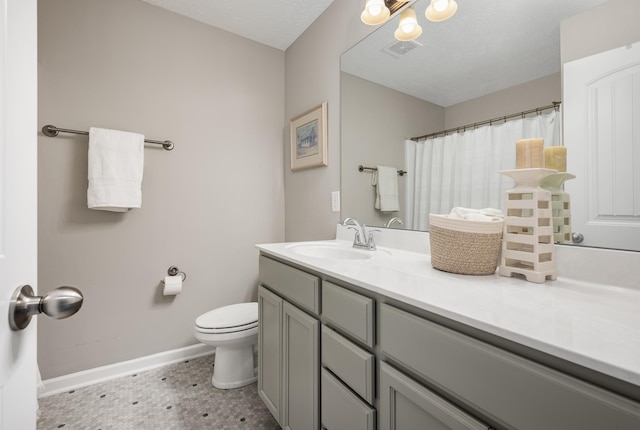 bathroom with vanity, toilet, a textured ceiling, and tile patterned flooring