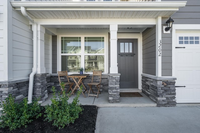 entrance to property with covered porch and a garage