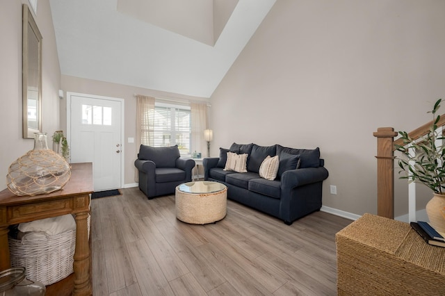 living room featuring high vaulted ceiling and light hardwood / wood-style floors