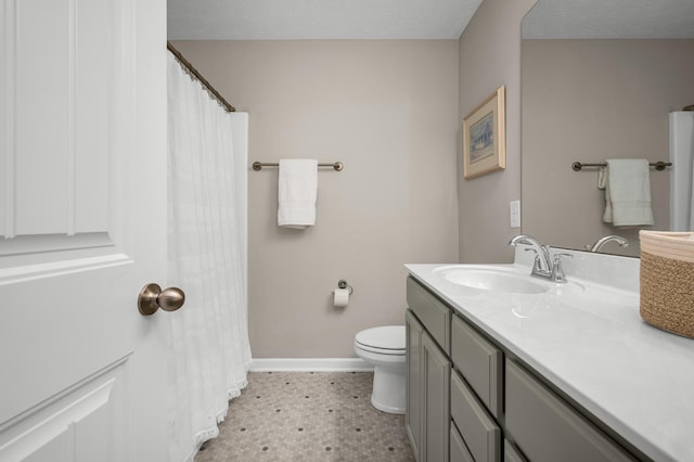 bathroom featuring toilet, a textured ceiling, and vanity