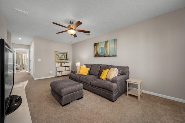 living room featuring carpet flooring, ceiling fan, and a textured ceiling